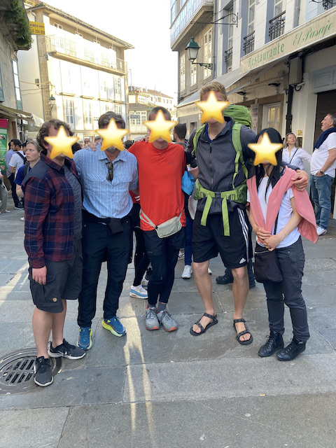 サンティアゴ・デ・コンポステーラの旧市街で肩を組んで並ぶ5人の巡礼者