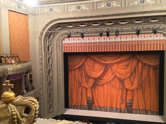 赤い緞帳が描かれた幕が掛かっている、二階席から見た舞台