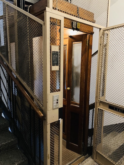 網のドアと木製のドアが二重になった、旧式のエレベーター