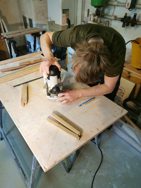 台の上で工具を使って木材を切っている男性