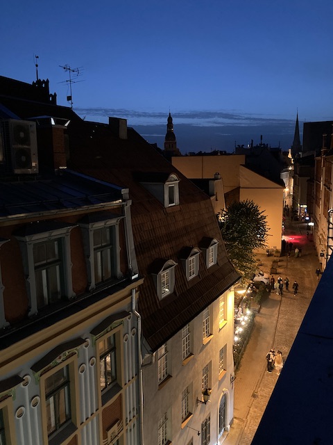 日が暮れて夜になる直前の深い青の空に、柔らかな照明で照らされた街路