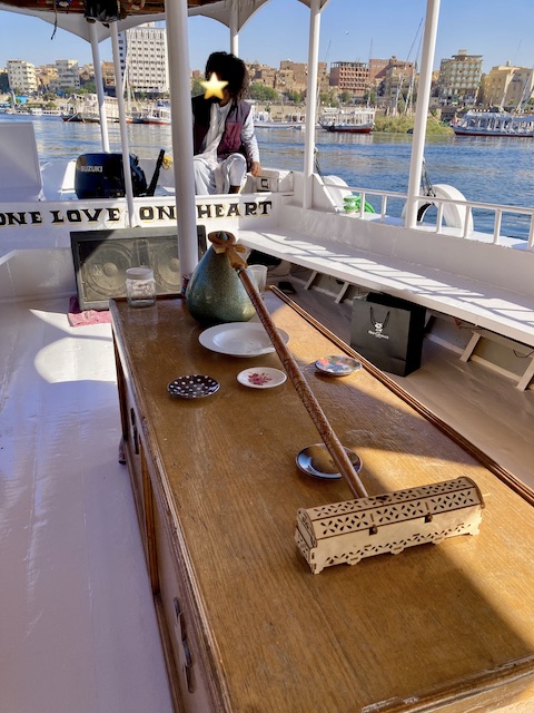 白塗りのボートの真ん中に置かれた木製のテーブルに、『生命の鍵』などのデコレーションが置かれている