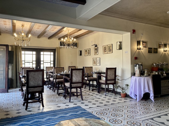 シャンデリア風の照明と、綺麗な模様のタイルの床がおしゃれな、ホテルのロビー兼朝食スペース