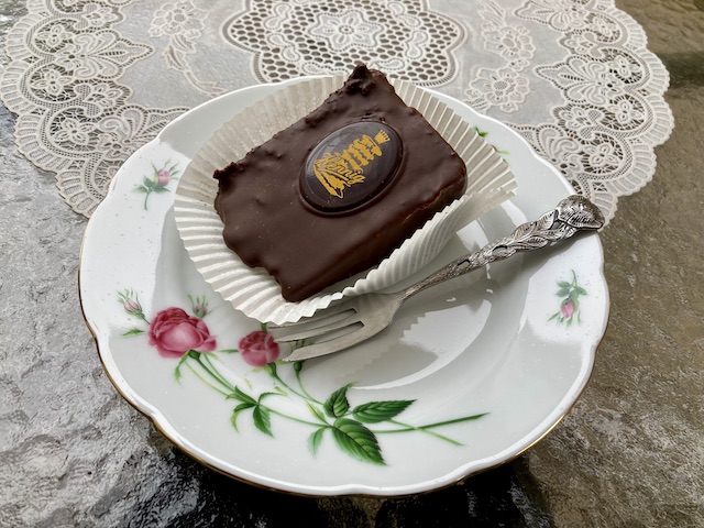 Hennigという名前とバウムクーヘンのマークが入ったチョコレートがついた、チョコレートコーティングのケーキ