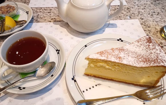 カフェのテーブルに並んだ紅茶とチーズケーキ