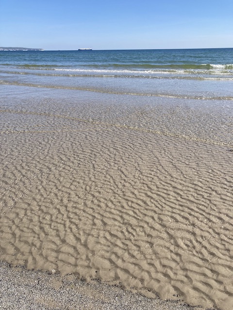 すぐ足元まで来ている透明な細波と、そこから繋がって遠くに見える青い海