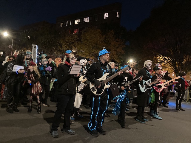 ガイコツやゾンビのようなメイクでギターを弾きながら歩いていくグループ