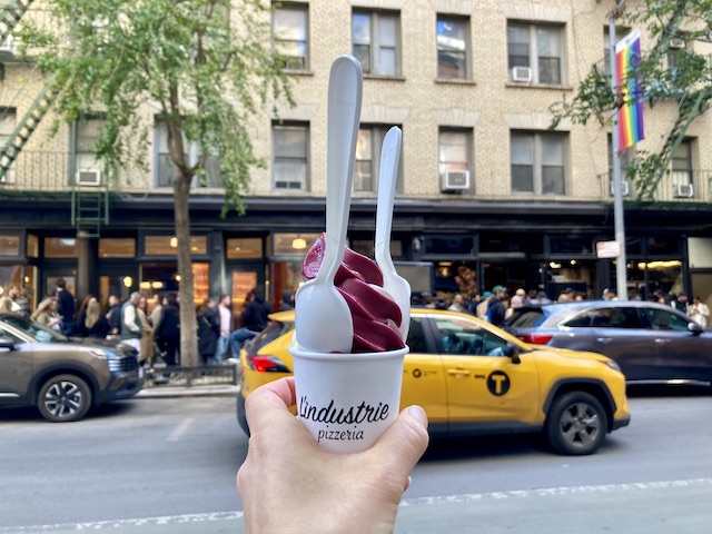 二色になったソフトクリーム状のアイスクリームと、背景に見えている道路と長蛇の列