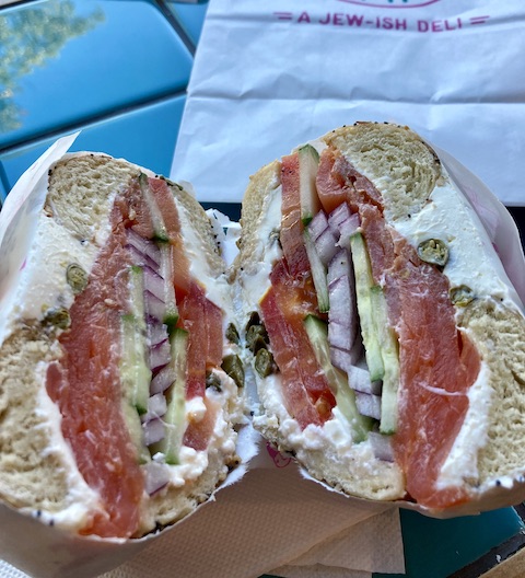 クリームチーズ、サーモン、きゅうり、レッドオニオン、トマトがこれでもかと挟まれているベーグルの断面