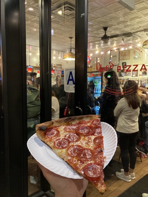 紙皿からはみ出す大きさの、ペパロニがたくさんトッピングされたピザ