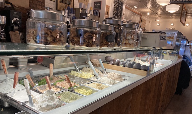 ガラスケースの中で山盛りになっている様々な色のクリームチーズ