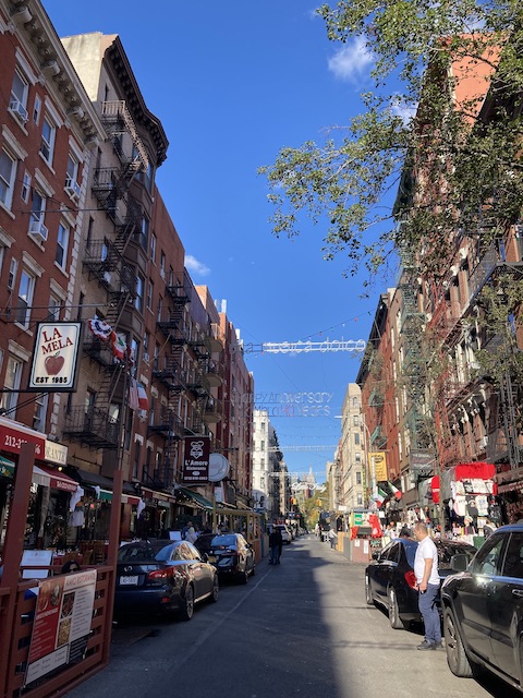 飲食店と車が並び、少し雑多な雰囲気のある通り