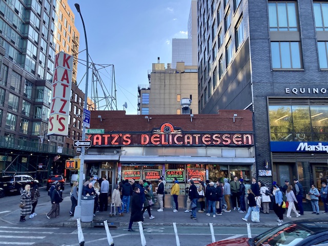 道路の角にある歴史の古そうなデリ店の前に並んでいる人達