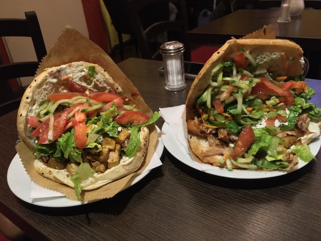 店内のテーブルの上にある、はみ出るほど具の入ったケバブサンド2つ