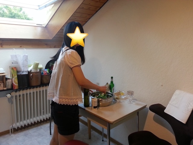 天窓があるキッチンのテーブルでサラダを混ぜている私