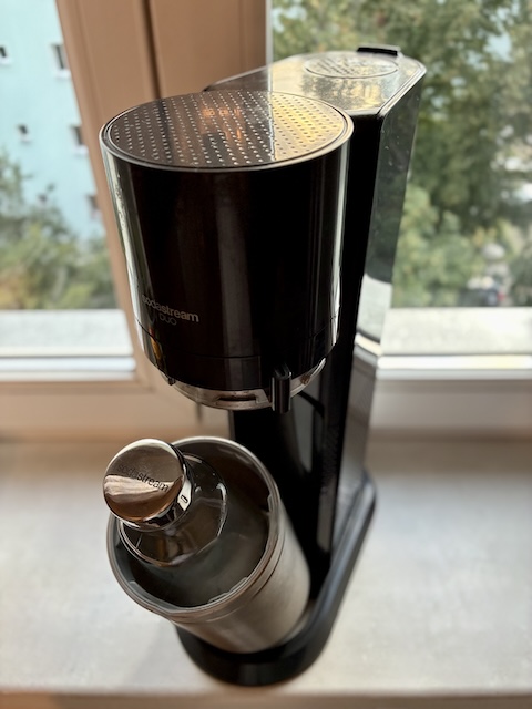 窓辺に置かれたSodaStreamの専用ガスシリンダーと、中にセットされた専用のボトル